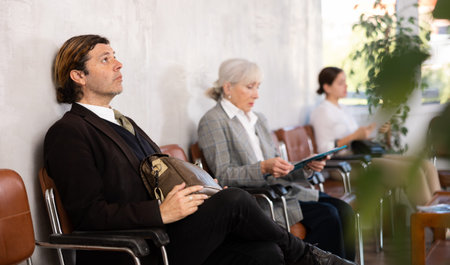 Adult man waiting for job interview on chair in office