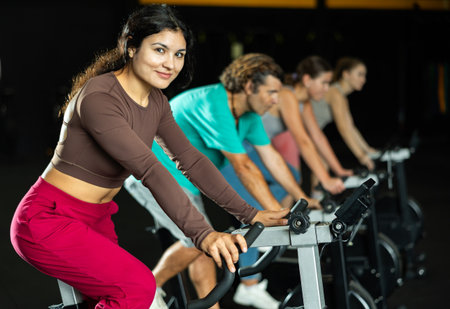 Latina woman exercising on an exercise bike in a crossfit gymの写真素材