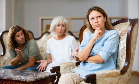 Domestic quarrel relatives in apartment. Adult offended woman turned awayの写真素材