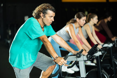 man doing exercises on a bicycle simulator during a crossfit workoutの写真素材