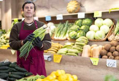 Man presents fresh garden onion, best option of vegetables from local and imported producers