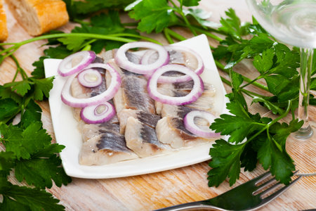 Marinated herring with sliced onion and parsleyの写真素材
