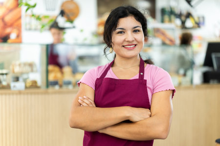 Young woman waitress invites to cafeの写真素材