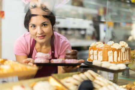 Bakery latino saleswoman offers to buy fresh cakesの写真素材