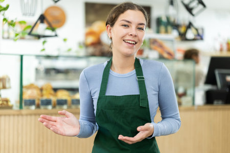 Polite waitress welcomes clients in cafeteria