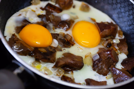 Fried eggs with red pine mushrooms in frying panの写真素材
