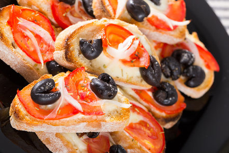 Tasty sandwiches with cheese, tomato and olives at plateの写真素材