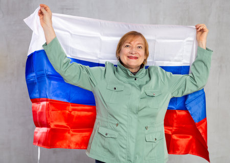 Smiling senior woman waving national flag of Russiaの写真素材