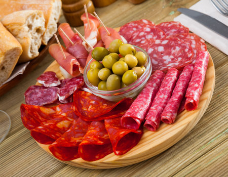 Slices of gammon, sausages on wooden boardの写真素材