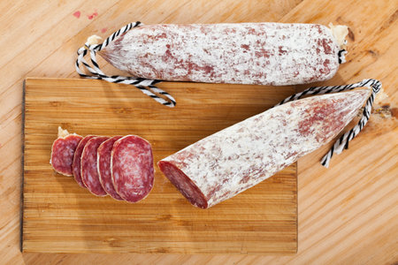 Spiced spanish longaniza sausages at wooden background