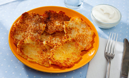 Belarusian potato pancakes draniki with sour cream at plate