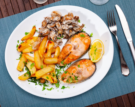 Deliciously steak of fried salmon with potatoes and mushroomsの写真素材