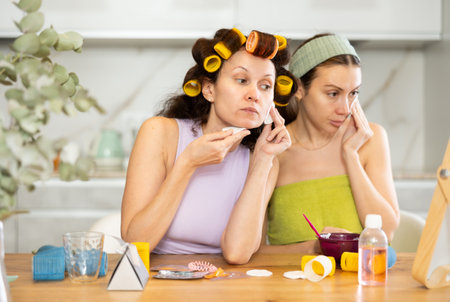Two women cleanse their face with cotton padsの写真素材