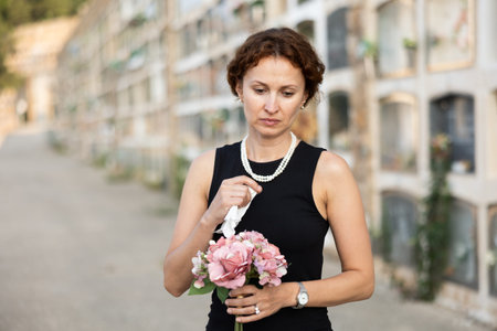 Woman brought flowers to the cemetery and cries over the death of beloved relativeの写真素材