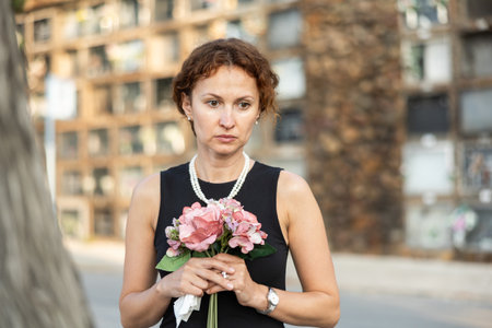 Woman brought flowers to the cemetery and cries over the death of beloved relativeの写真素材