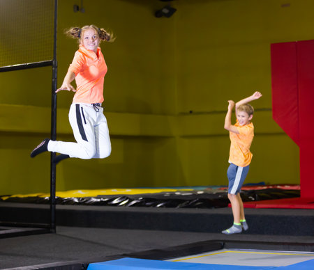 Happy cute little girl jumping on trampoline indoorsの写真素材