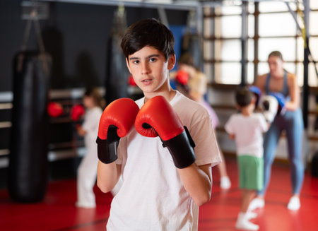 Teenage boy with boxing gloves in gymの写真素材