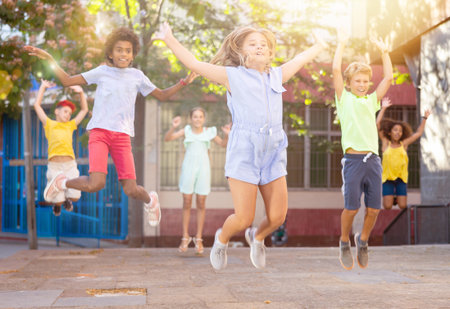 Happy multiracial boys and girls jumping outdoorsの写真素材