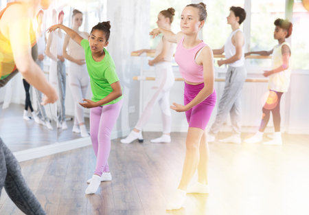 Group of teenage dancers training ballet in studio