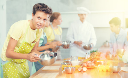 Teen boy participating in culinary workshop led by professional chefs for tweensの写真素材