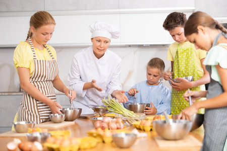 At cooking course, woman cook tells children about rules of cooking fluffy pancakesの写真素材