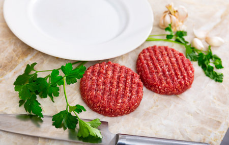 Raw beef patties for burgers with greens and garlicの写真素材