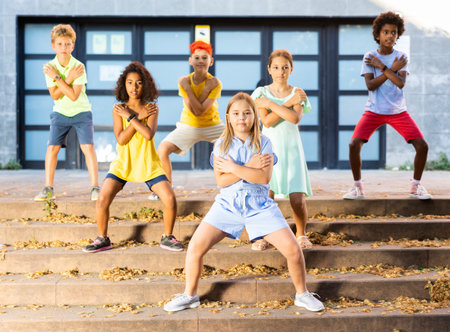 Positive preteen boys and girls dancing on city streetの写真素材
