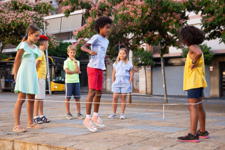 Children playing with jumping rope outdoorsの写真素材