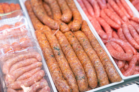 Sausages made of pork and chicken minced meat ready for grilling in meat shopの写真素材