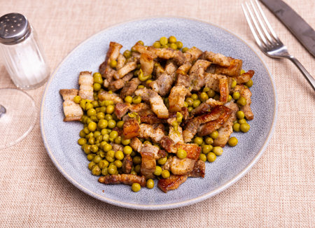Pieces of fried pork belly with green peas closeupの写真素材