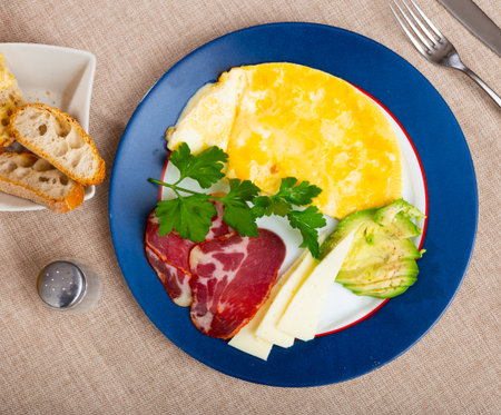 Omelet with avocado, jamon and cheese on a plateの写真素材