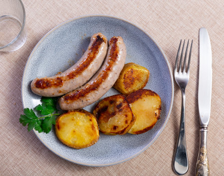Hearty meal consists of fried sausages and potatoesの写真素材