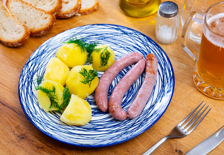 Cooked sausages with potatoes on a plateの写真素材