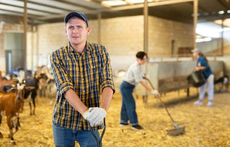 Farmer does the cleaning in goat shedの写真素材