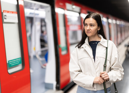 Female passenger awaits the metro train at arrival stationの写真素材