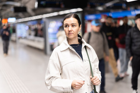 Girl is standing on metro platform station, waiting for transport to arriveの写真素材