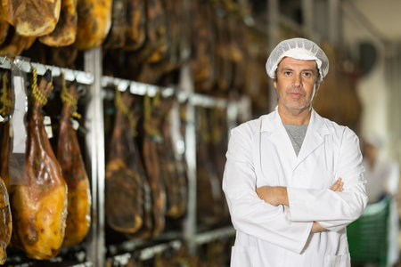 man factory employee stands against the background of jamonの写真素材