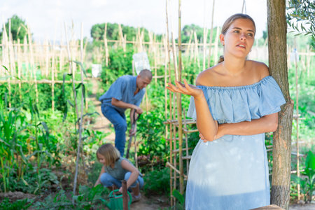 Displeased young woman does not want to work in the summer gardenの写真素材