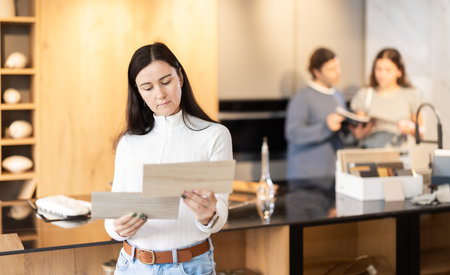 Adult woman choosing wood for floor in furniture salonの写真素材