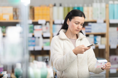 Woman in pharmacy scans QR code on paracetamolの写真素材