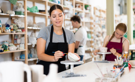 Teenagers are interested in making dishes from clay in pottery workshopの写真素材