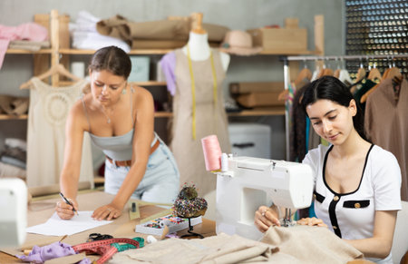 Female dressmakers working together in a sewing workshopの写真素材
