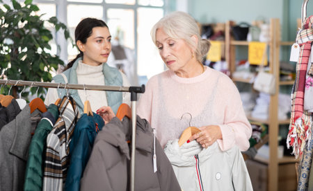 Two women of different ages choosing clothes in a storeの写真素材