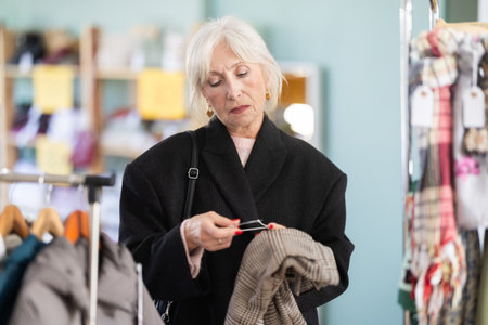 Elderly woman choosing woolen pantsの写真素材