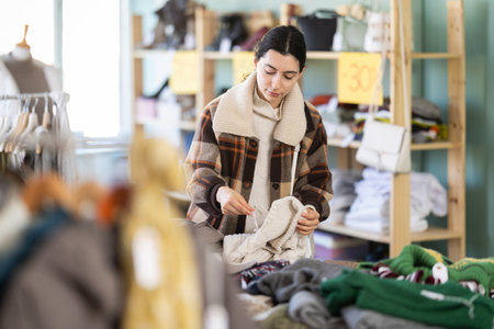 Regular customer woman chooses color and style of sweaterの写真素材