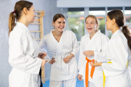 Group of young women are talking after successful and tedious karate workout.の写真素材