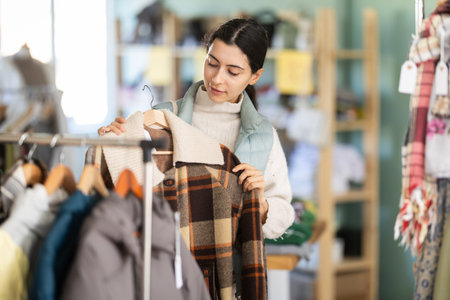 Woman choosing outerwear in the storeの写真素材