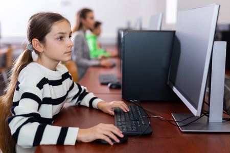 Schoolgirl using PC during computer science lessonの写真素材