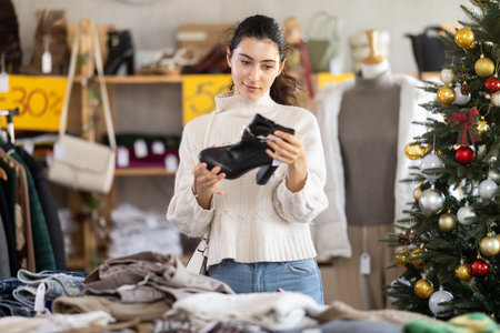 Armenian woman choosing heeled ankle boots in Christmas shopの写真素材