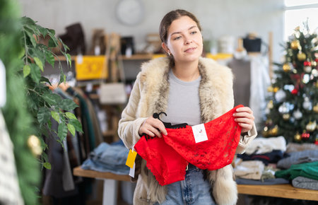 Young woman choosing red panties in the store for the new yearの写真素材